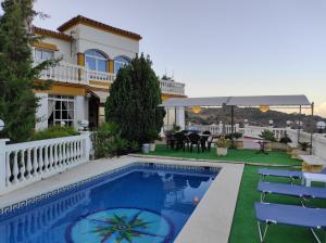 a villa with a swimming pool and a house at La huerta de Bonela in Casarabonela