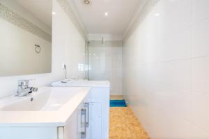 a white bathroom with a sink and a mirror at Wonderful in Can Picafort +22 photos