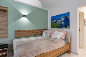 a bedroom with a large bed with a wooden headboard at Fewo-Gottmadingen in Gottmadingen