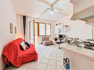 a living room with a red couch in a kitchen at Bilo Le Lecce 15b in Capoliveri