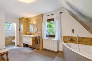 a bathroom with a tub and a sink and a mirror at Haus Schwarzwald Königin in Bühlertal +28 photos
