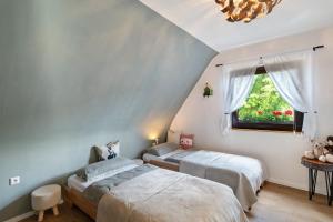 two beds in a room with a window at Haus Schwarzwald Königin in Bühlertal