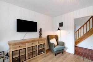 a living room with a tv and a chair at Haus Schwarzwald Königin in Bühlertal