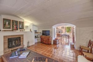 a living room with a fireplace and a tv at Sa Cabana Vella Fornalutx in Fornalutx