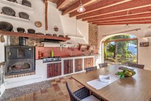 a kitchen with a wooden table and a large fireplace at Sa Cabana Vella Fornalutx in Fornalutx