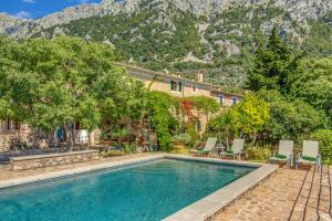 a pool in front of a house with mountains in the background at Sa Cabana Vella Fornalutx in Fornalutx