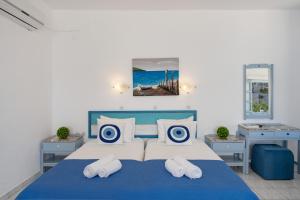 a bedroom with a blue and white bed with pillows at Pico Bello Patmos 16 in Patmos