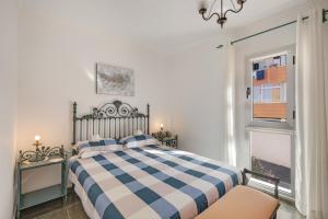 a bedroom with a checkered bed and a window at Casa Goro in Tazacorte