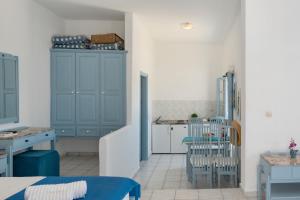 a kitchen with blue cabinets and a table at Pico Bello Patmos 16 in Patmos