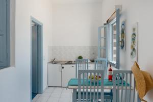 a kitchen with two blue chairs and a table at Pico Bello Patmos 16 in Patmos +20 photos