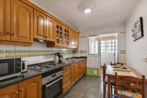 a kitchen with wooden cabinets and a stove top oven at Casa Goro in Tazacorte