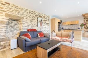 a living room with a blue couch and a table at Le Penty - proche plages et centre in Concarneau