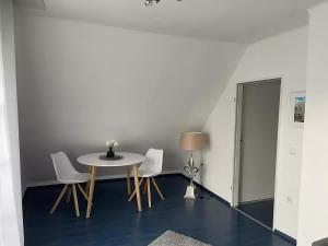 a table and chairs in a room with a white wall at room4rent in Lingen