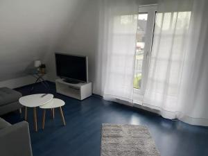 a living room with a tv and a table at room4rent in Lingen