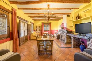 a living room with a tv and a fireplace at Cortijo Jiménez in Pitres