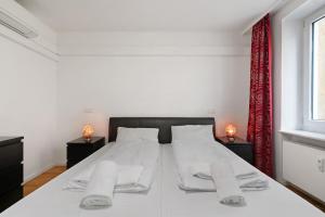 a bedroom with a large white bed with two night stands at Aldars Urban Grand Suite No.15 in Munich