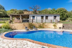 a swimming pool with a house in the background at Cortijo Jiménez in Pitres