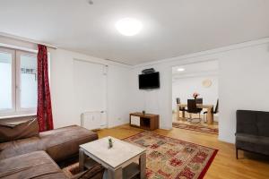 a living room with a couch and a table at Aldars Urban Grand Suite No.15 in Munich