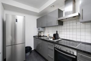 a kitchen with a stainless steel refrigerator and a sink at Aldars Urban Grand Suite No.15 in Munich