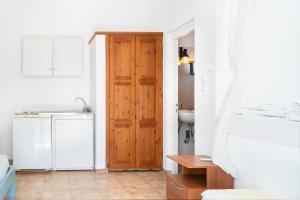a bathroom with a wooden door and a sink at Beachfront Lampis Dolphin 3 in Skala