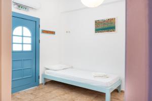 a room with a bed and a blue door at Beachfront Lampis Dolphin 3 in Skala +21 photos