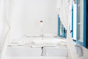 a white bed in a room with a window at Beachfront Lampis Dolphin 3 in Skala