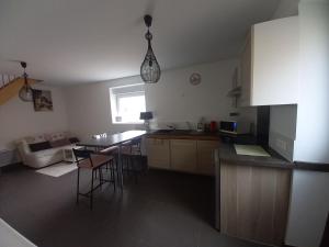 a kitchen and living room with a table and chairs at A La Cour Basse in Peltre