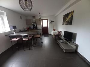 a kitchen and living room with a table and chairs at A La Cour Basse in Peltre