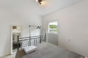 a white bedroom with a bed and a window at Casa Verde Sauerland in Lennestadt