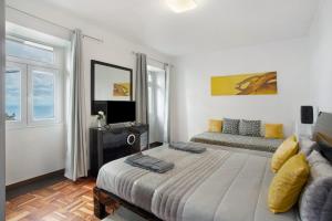 a bedroom with a large bed and a couch at Carros De Cesto Do Monte in Funchal