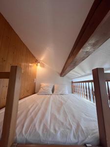 a bed in a room with a wooden ceiling at Au Rêve Savoyard 6 - 4 personnes in Morillon