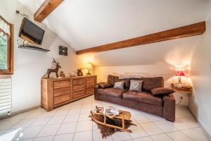 a living room with a couch and a tv at Au Rêve Savoyard 6 - 4 personnes in Morillon