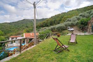 two chairs sitting in the grass next to a house at Câ de Bacî in Vessalico