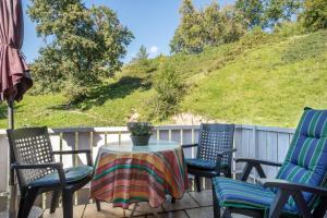 a table and chairs on a patio with a hill at Annemarie und Walter Hechelmann in Lindau