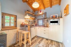 a kitchen with white cabinets and a wooden floor at Mini Country House in Sidari