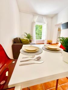 a table with plates and silverware on it in a living room at Apartamento centro 1-B in Huelva
