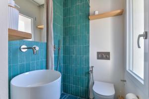 a bathroom with a tub and a toilet at Casa Azzurrina Mare in Seccheto +21 photos