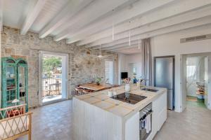 a kitchen with a stone wall and a table at Casa Azzurrina Mare in Seccheto