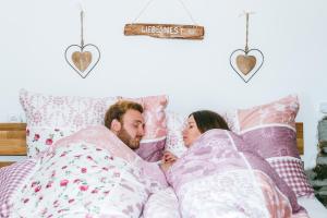 a man and a woman laying in bed at Connyhaus St Oswald ob Eibiswald in Sankt Oswald ob Eibiswald