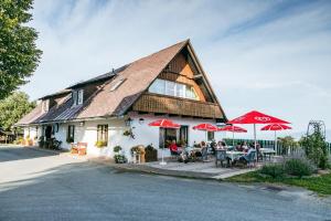 a building with people sitting at tables in front of it at Connyhaus St Oswald ob Eibiswald in Sankt Oswald ob Eibiswald