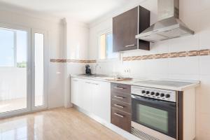 a white kitchen with a stove and a window at Ferrera Soul 2b in Felanitx