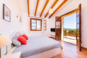 a bedroom with a bed and a sliding glass door at Can Carboneta in Artá