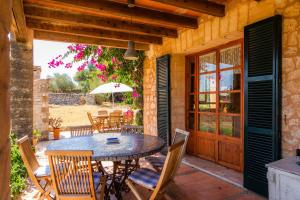 a patio with a table and chairs and an umbrella at Can Carboneta in Artá