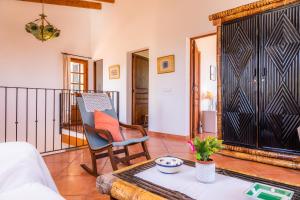a living room with a chair and a table at Can Carboneta in Artá +22 photos