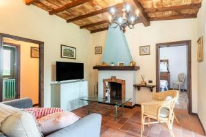 a living room with a fireplace and a tv at Pietraserena - San Gimignano in San Gimignano