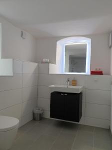 a white bathroom with a sink and a toilet at wohnung-nummer-2 in Pielenhofen +4 photos