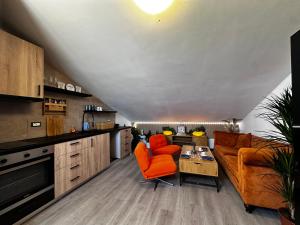 a living room with orange chairs and a couch at Nice and cozy apprtment in Murazzano with panoramic view in Murazzano