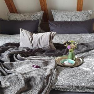 a bed with a blanket and a vase of flowers on it at Alb - Lotte in Bitz