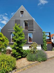a gray house with a tree in front of it at Alb - Lotte in Bitz