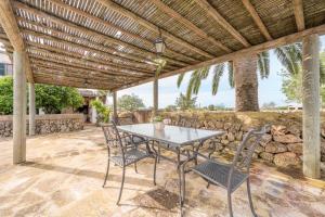 a patio with a table and chairs under a wooden pergola at Son Rossinyol Nou - 12 personas in Islas Baleares